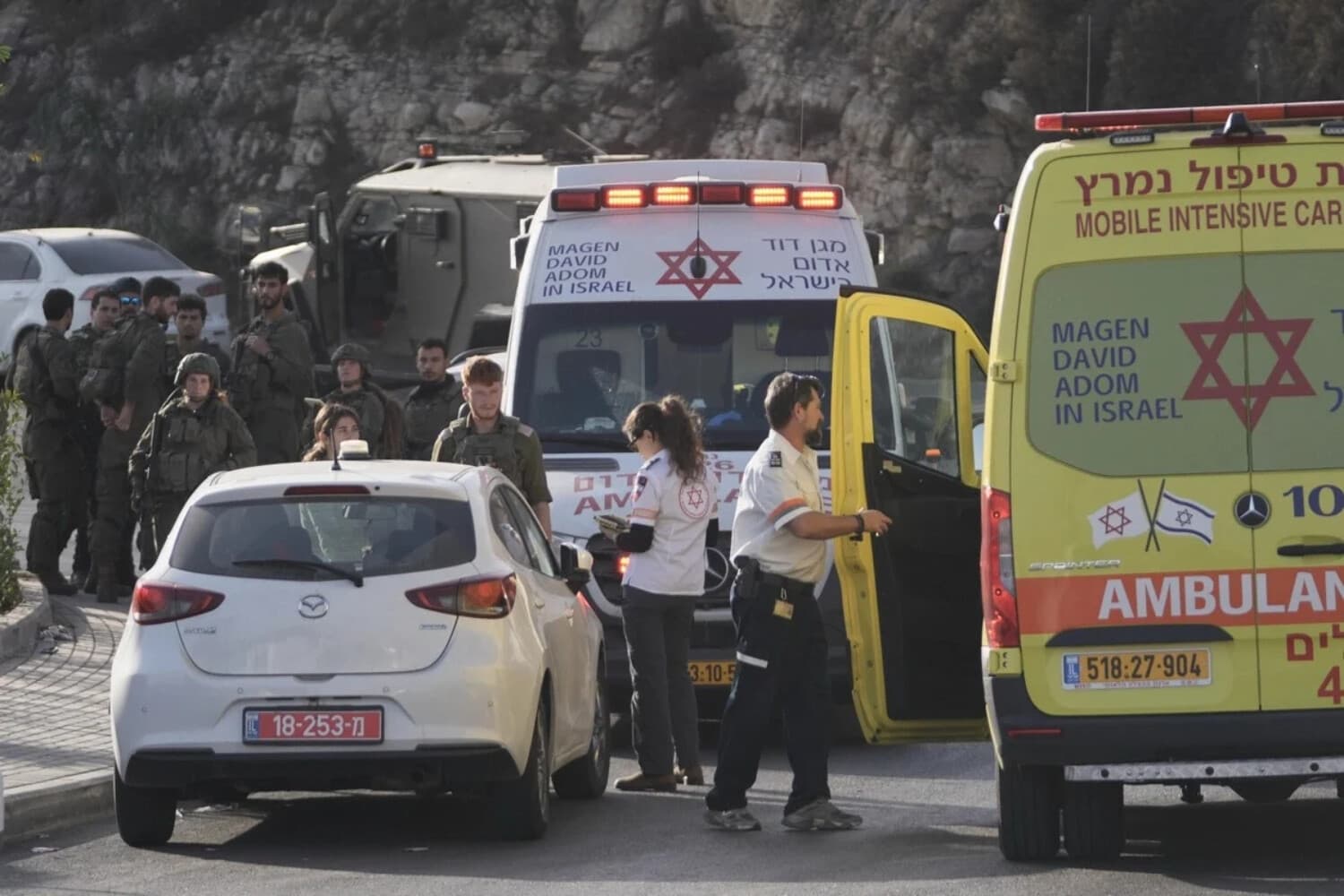 Soldados israelíes y personal de emergencia se reúnen cerca de ambulancias tras un ataque a tiros cerca del cruce de Yehuda, cerca de Hebrón, en Cisjordania ocupada, el 23 de octubre de 2026. (Mahmoud Illean/AP).