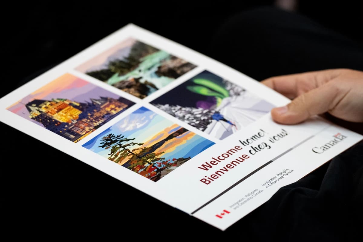 Un nuevo ciudadano canadiense sostiene un folleto de bienvenida durante una ceremonia de ciudadanía canadiense en Ottawa el 22 de noviembre de 2023. (The Canadian Press/Spencer Colby).