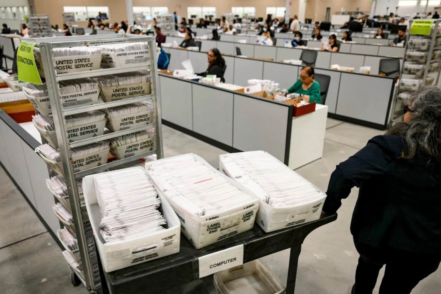 Un miembro del personal electoral traslada las boletas de voto por correo para organizarlas de cara al recuento en la ciudad de Industry, California, el 2 de junio de 2026. (Patrick T. Fallon/AFP vía Getty Images)