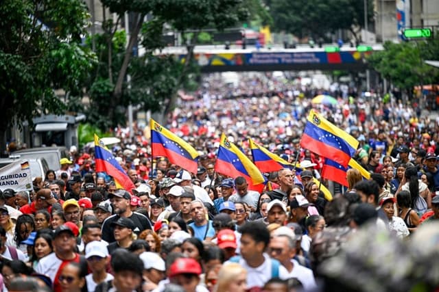 Partidarios del gobierno de Venezuela participan en una marcha en apoyo al proceso de diálogo entre un sector de la oposición y el gobierno, y para exigir el levantamiento de las sanciones, en Caracas, Venezuela, el 13 de octubre de 2026. (Federico Parra/AFP vía Getty Images)
