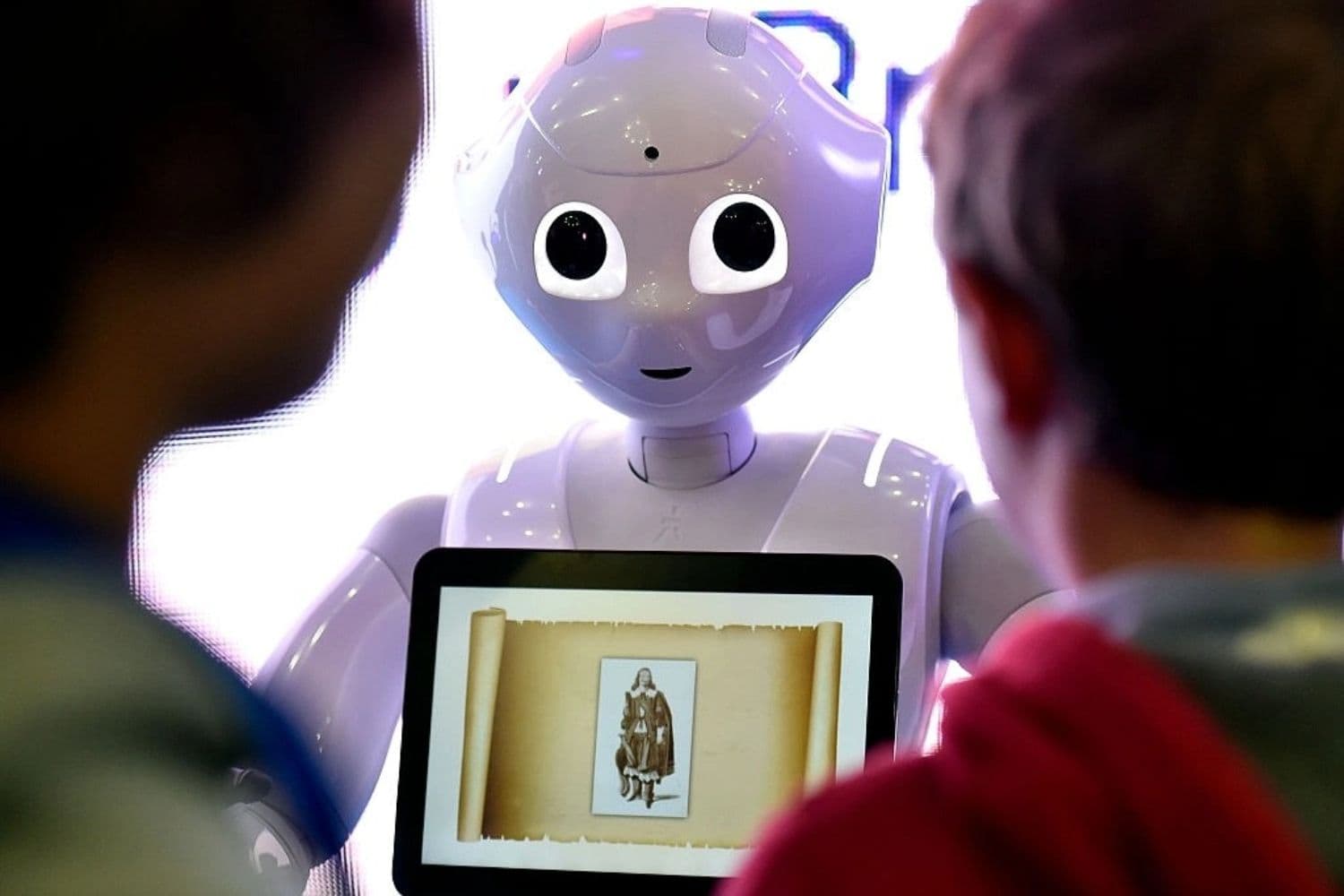 Fotografía de archivo en la que se ve a unos niños interactuando con un robot humanoide programable durante la Global Robot Expo celebrada en Madrid, España, el 31 de enero de 2016. (Gerard Julien/AFP vía Getty Images)