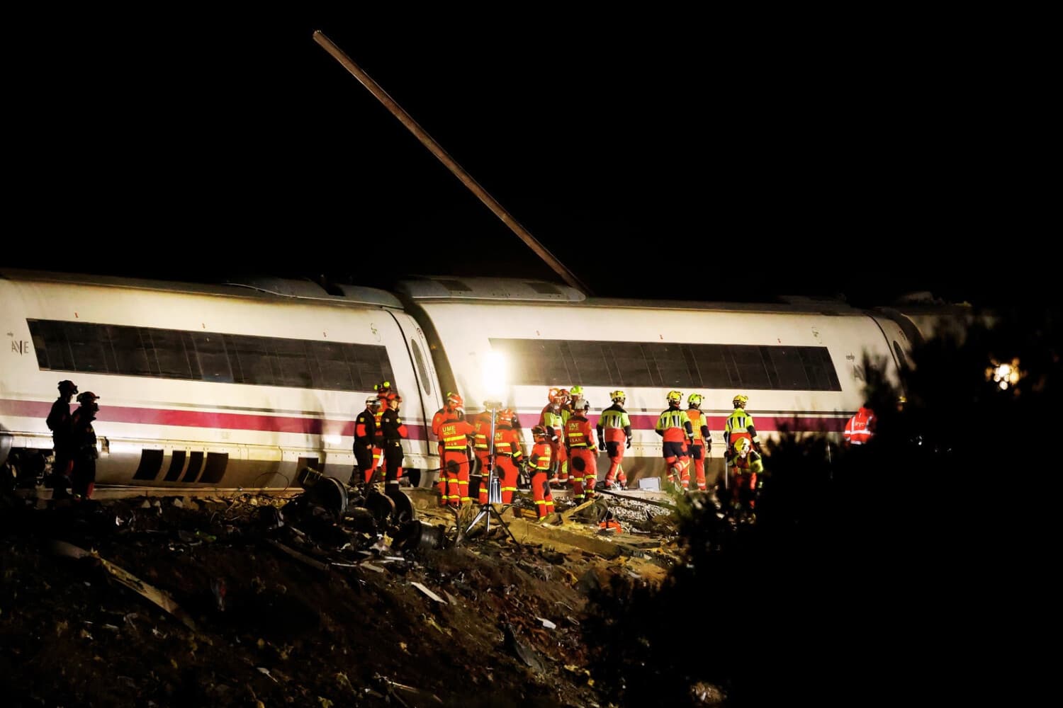 Miembros de los servicios de emergencia y rescate trabajan junto a un vagón atravesado por un raíl en el lugar del accidente ferroviario entre dos trenes de alta velocidad, un AVE de Renfe y un tren de Iryo, a unos 150 km al sur de Madrid, entre Urda y Los Yebenes, en la provincia de Toledo, el 28 de octubre de 2026. (Oscar DEL POZO / AFP vía Getty Images)