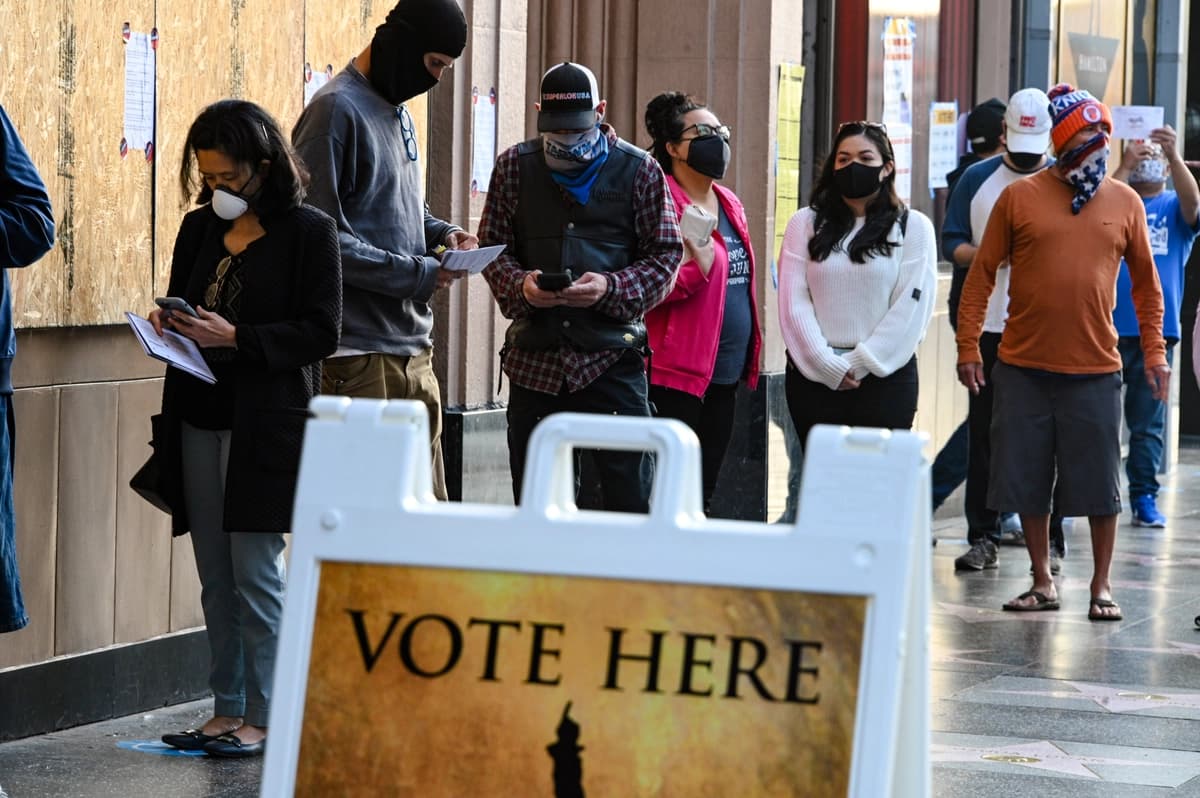 Personas hacen fila en el Teatro Pantages, en el Paseo de la Fama de Hollywood, para votar en las elecciones presidenciales de Estados Unidos entre el presidente en ejercicio Donald Trump y el candidato demócrata Joe Biden, en Los Ángeles, el 3 de noviembre de 2020.(Foto de ROBYN BECK/AFP vía Getty Images).